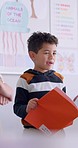 Boy, reading and book with presentation, learning or oral assessment at school, development or language. Male kid, story and speech with test, teacher and education with project, classroom or academy