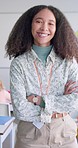 Female teacher, arms crossed and smile in classroom, school and pride on face for education career. Woman, classroom and learning expert for children, happy or portrait with development for future