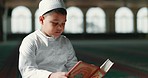 Islam, child in mosque reading Quran for learning, mindfulness and gratitude in faith with prayer. Worship, religion and Muslim student in holy temple praise with book, spiritual teaching and study.