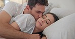 Cuddle, couple and kiss in bedroom, happy and bonding together in romance. Intimate embrace, man and woman on bed, care and love in connection of healthy relationship, commitment and marriage at home