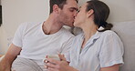 Coffee, couple and kiss in bedroom, smile or bonding together in romance. Intimate, man and woman on bed with tea, care and connection in healthy relationship, commitment to love and marriage at home