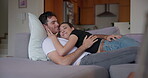 Couple, hug and lying on sofa for love, care and relax together with trust, comfort and support at home. Happy man, woman and cuddle with kiss, conversation and loyalty to romantic partner in lounge