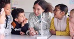 Education, windmill and teacher with students in class learning clean energy or eco friendly information. Science, sustainability and woman teaching natural power or electricity to children at school