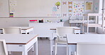 Empty, classroom and interior of school in education with whiteboard, desk and chairs in morning. Class, equipment and furniture for learning, teaching and room for students to study