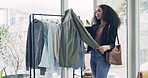 Fashion, shopping and shirt with woman in store for boutique, sale and retail. Product, clothes and search with customer and clothing rack option in mall for decision, choice and inspiration