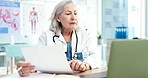 Laptop, telehealth and doctor with report on a video call for online medical consultation in her office. Document, discussion and senior woman healthcare worker with virtual diagnosis in a hospital.