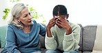 Therapy, sad and woman crying on a sofa with psychologist for depression, anxiety or mental health. Stress, grief and senior psychiatrist comforting an Indian female patient in session in her office.