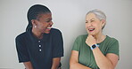 Senior woman, laughing or happy caregiver talking for healthcare support on a white background. Smile, wall or friendly nurse speaking of joke to a funny mature person with love, wellness or care