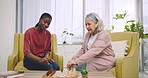 Senior woman, caregiver and game of chess, living room or thinking with strategy, competition or moving. Elderly lady, carer and board for contest, goal or high five for chat, advice and nursing home