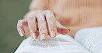 Hand, reading and woman with a bible, book and study of religion in living room, home or learning about spiritual knowledge. Christian, education and studying holy scripture of God, Jesus or faith