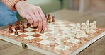 Chess, hands and knight in a home with pawn, board game and strategy development plant. Table, chessboard and competition with planning a contest move with challenge of people playing in a house