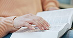 Hand, bible study and woman reading a book of Christian religion in living room, home and learning about spiritual knowledge. Gospel, education and research of holy scripture of God, Jesus or faith
