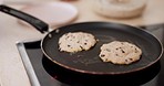 Cooking, closeup and pancakes frying in a pan on a stove in the kitchen of a modern home. Baking, dessert and zoom of chocolate chip crepes for a sweet breakfast, lunch or brunch meal or snack.