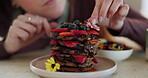 Pancake stack, decoration and hands, breakfast and food with person in kitchen with creativity and nutrition. Edible flowers, pastry chef and cooking with fruit, closeup of meal with art and catering