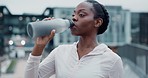 City. fitness and black woman drinking water, tired and health with hydration, workout and training. African person, athlete or runner with a bottle, exercise or aqua with wellness, thirsty or energy