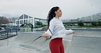 Woman, fitness and skipping rope in city for workout, cardio exercise or outdoor training. Active female person or athlete jumping in healthy wellness, body or lose weight in muscle endurance in town