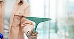 Hands, spray bottle and a person cleaning a window in an office closeup for hygiene or responsibility. Glass, soap and disinfection with a cleaner in a workplace for maintenance or sanitization