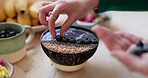 Woman, hand and blueberry bowl in diet, natural nutrition or morning breakfast on kitchen table. Closeup of female person adding healthy organic fruit mixture, dessert or muesli cereal in lose weight