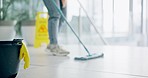 Cleaning, person and mop on floor of office for cleaner service, professional janitor and maintenance. Manual labor, wet sign and worker with tools for hygiene, disinfection and washing in workplace