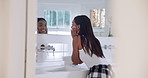 Skincare, woman and touching face in mirror for wellness, luxury and self care in bathroom of home. Cosmetic, person and facial treatment, happiness or natural for morning routine, beauty or glow
