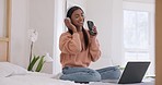 Headphones, phone and woman singing in bedroom with lyrics on laptop for fun and entertainment. Technology, happy and young Indian female person listen to music, radio or playlist in modern apartment