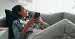 Woman, thinking and typing on smartphone on sofa, scroll social media and reading notification at home. Cellphone, relax and search connection, download digital app and mobile contact in living room