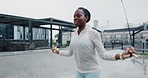 Black woman, fitness and skipping rope in city for workout, cardio exercise or outdoor training. African female person jumping in healthy wellness, body or lose weight in muscle endurance in town