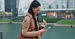 Phone, walking and woman in rain with gps in city typing on social media or search location on internet or app in morning. Winter, umbrella and person on vacation and chatting with connection