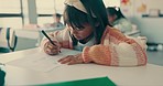 Girl child, classroom and writing test with paper, thinking and assessment for knowledge, progress and info. Female kid, exam or quiz with pen, ideas and learning for future, education and evaluation