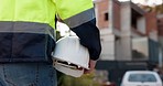 Man, construction worker and helmet in hand, maintenance with engineering and contractor walking with back view. Infrastructure, building site and manual labor with architecture and handyman outdoor