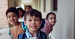 Happy, face and children in line at school in kindergarten, classroom and learning. Portrait, waiting and group of kids smile, students and friends in hallway for education, knowledge and studying