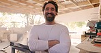 Wood, arms crossed and face of man in workshop for manufacturing, carpenter and furniture. Renovation, handyman and tools with portrait of person at home for house remodeling, garage or trade project