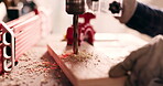 Wood, closeup and drill with person in workshop for furniture, manufacturing and renovation. Production, tools and design with handyman and equipment in home garage for remodeling, board and dust