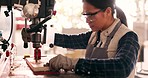 Carpenter woman, industry drill and wood for construction, check and manufacturing with safety in workshop. Woodwork expert, tools and plank in garage warehouse or  hardware with ppe glasses for eyes