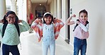 Strong, happiness and flexing muscle with children at school for growth and development with backpack and smile. Education, students and fitness with motivation for knowledge and energy with friends