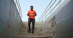 Man, fitness and running on steps outdoor for exercise, cardio workout and sports training. African runner, urban performance and action on stairs for energy, wellness and strong endurance challenge