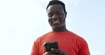 Outdoor, fitness and black man with a cellphone, typing and digital app with social media, meme and healthy. Smile, African person and runner with a smartphone, mobile user and connection in a city