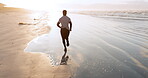 Man, beach and running in fitness, workout or exercise for outdoor training, motivation or cardio. Rear view of active male person, athlete or runner in sports, lose weight or healthy wellness by sea