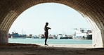 Time check, running and a black man at the beach for a break, fitness or training monitor. Tunnel, dark and an African runner or athlete with a watch for check during cardio, workout or exercise