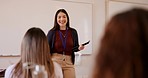 Teacher woman, classroom and talking by board, tablet and questions with smile, education and information. Professor, high school or college with knowledge, advice and happy for student development