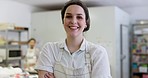 Happy woman, portrait and smile in bakery with employee, apron and working in cafe kitchen with service and catering. Face, baker and laughing with arms crossed, confidence and professional chef