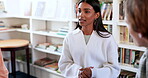 Talking, students or woman in library for education, knowledge or study group for college project. Learning, university or people in conversation with studying talk or teamwork in school for research