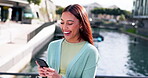 Phone, wow and notification with a woman excited as a lottery winner while outside on a bridge across a river. Contact, surprise and good news with a happy young person reading an alert on her mobile