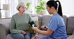Blood pressure, test and caregiver help senior woman on retirement with consultation on couch in home for support. Care, medical and nurse with advice for elderly person in healthcare exam on sofa