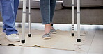Support, walking and feet of patient and nurse with walker, help or recovery. Home care, physiotherapy and woman with a disability, aid and caregiver or physiotherapist for healing or rehabilitation