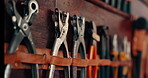 Workshop, tools and wall with equipment on shelf at a workplace for maintenance and creativity. Set of metal objects on a leather belt for art, engineering and craft manufacturing with pliers