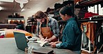 Man, woman and talking in textile warehouse for writing, idea and fabric sample for leather manufacturing. Design partnership, notes and book for stock, material or cloth for brainstorming in factory