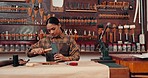 Leather workshop, woman at table with tools and craft manufacturing of unique textile product. Hammer, fabric and girl at tannery factory with pattern, service and repair process at creative shop.