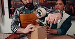 Production, leather workshop and industry team packing an order in cardboard box. Industrial, collaboration and young man and woman with ecommerce small business for tanning process in manufacturing.