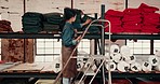 Tablet, leather workshop and woman at shelf on ladder for fabric choice. Tech, craft and person select tannery textile in factory for production, manufacturing and walking on steps in small business